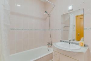 a bathroom with a sink and a tub and a mirror at Esfera I Calm Stay With Parking & Workspace in Caniço +11 photos
