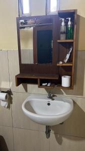a white sink in a bathroom with a mirror at Awang Homestay in Bumbang +16 photos