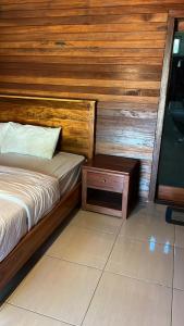 a bedroom with a bed and a wooden wall at Awang Homestay in Bumbang
