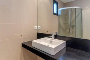 a bathroom with a white sink and a mirror at Jardins Do Oceano Ii Modern Stay Near Beach in Caniço