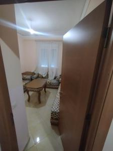 a hallway with a room with a table and a door at Comp al Farah in Tangier +3 photos