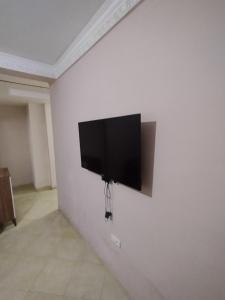 a flat screen tv hanging on a white wall at Comp al Farah in Tangier
