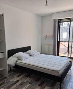 a bedroom with a bed in a room with a window at Kirollos in Montlhéry