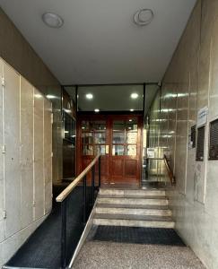 a hallway of a building with a wooden door and stairs at Funcional Lamadrid 62 in Bahía Blanca
