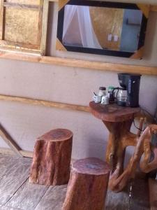 a table with a coffee maker and two logs at Waikiki Pacific Hostel in Buenaventura +29 photos