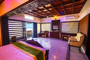 a bedroom with a bed and a living room at Clifinn Wellness Beach Resort by nutmeg in Trivandrum