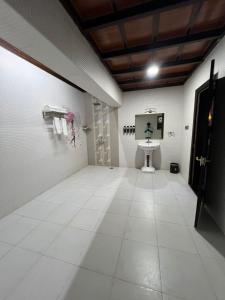 a room with a white tiled floor with a sink in it at Clifinn Wellness Beach Resort by nutmeg in Trivandrum