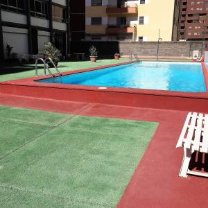 uma piscina com um banco num edifício em Apartamento en la Rambla con piscina em Santa Cruz de Tenerife