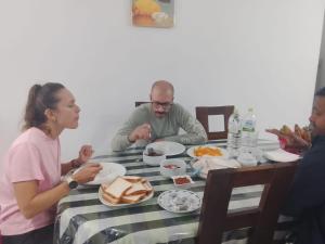 a group of people sitting around a table with food at Devil mountain guest in Kalupahana +40 photos