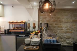 a kitchen with a counter with food and drinks at Hôtel De La Herse d'Or in Paris