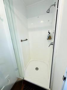 a white shower with a toilet in a bathroom at Delight at Golf in Auckland +60 photos