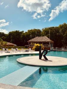 a swimming pool with a statue in the middle of it at SWEET HOME plage privée in Folle Anse