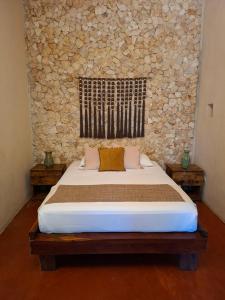 a bed in a room with a stone wall at Hotel Boutique Refugio 41 in Valladolid +35 photos