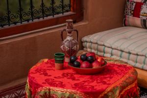 a table with a bowl of fruit on top of it at Ijoukak Berber HomeStay in Ijjoukak +86 photos