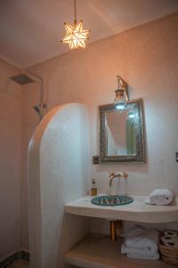 a bathroom with a sink and a mirror at Ijoukak Berber HomeStay in Ijjoukak