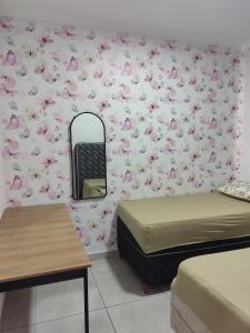a room with two beds and a mirror and pink flowers at Apartamento Moderno e Confortável in Lavras