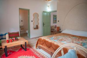 a bedroom with a bed and a table in it at Ijoukak Berber HomeStay in Ijjoukak
