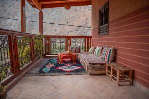 a screened in porch with a couch and a table at Ijoukak Berber HomeStay in Ijjoukak