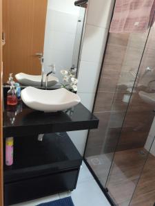 a bathroom with a sink and a shower at Apartamento Moderno e Confortável in Lavras