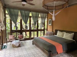 a bedroom with a bed and a large window at Nguyet Bieu Riverside in Thôn Kim Long (1)