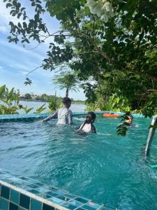 a group of people in the water in a swimming pool at Nguyet Bieu Riverside in Thôn Kim Long (1)