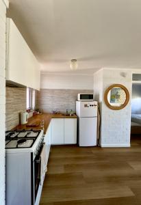 a kitchen with a stove and a white refrigerator at Right in Fremantle in Fremantle