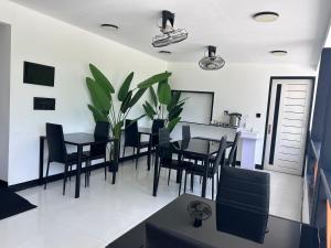 a dining room with black chairs and a table at Alyraa Sunset Mathiveri - Free Picnic Island Trip Included in Mathiveri