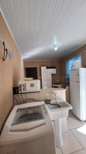 a kitchen with a sink and a white refrigerator at Casa ideal in São Caetano do Sul +2 photos
