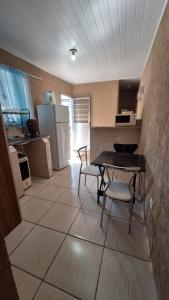a kitchen with a table and chairs and a refrigerator at Casa ideal in São Caetano do Sul