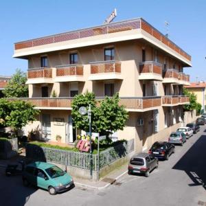 un edificio con auto parcheggiate di fronte di Hotel Giulia a Marina di Massa