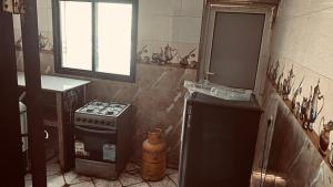 a small kitchen with a stove and a window at Berbera aparthotel in Berbera +14 photos