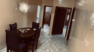 a dining room with a table and chairs and a hallway at Berbera aparthotel in Berbera