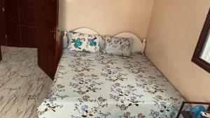 a bedroom with a bed with a floral bedspread at Berbera aparthotel in Berbera
