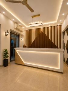 a lobby with a large white reception desk with at Hotel Satwah Luxe Stay - 1 Minute From Nizamuddin Railway Station And India Gate in New Delhi