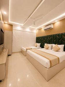 a hotel room with two beds and a television at Hotel Satwah Luxe Stay - 1 Minute From Nizamuddin Railway Station And India Gate in New Delhi +107 photos