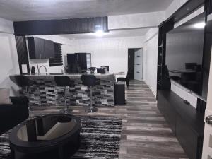 a room with a kitchen and a living room at Black House in Anasco