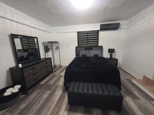 a bedroom with a black bed and a dresser at Black House in Anasco