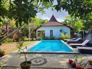 a swimming pool in front of a house at Serah's Homestay in Kuta Lombok