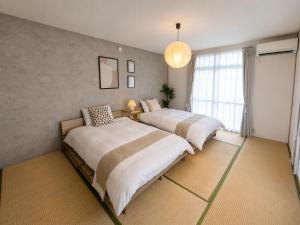 a bedroom with two beds and a window at Forest Agata in Matsumoto