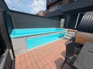 a swimming pool on a patio next to a building at Coco Resort Futtsu in Futtsu