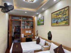 a hotel room with two beds and a desk at An's Home in Hanoi