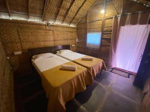 a bedroom with two beds with towels on them at Sunshine café Hampi in Hampi
