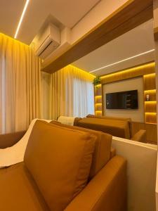 a hotel room with two beds and a flat screen tv at Studio Mandarim Campolim in Sorocaba