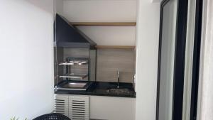 a kitchen with a sink and a counter top at Studio Mandarim Campolim in Sorocaba