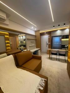 a large living room with a couch and a tv at Studio Mandarim Campolim in Sorocaba