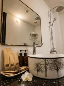 a bathroom with a bath tub with trees painted on it at Tam Coc Sylvani Homestay in Vũ Lâm +23 photos