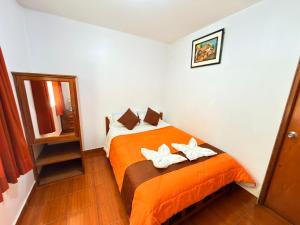 a bedroom with a bed with two white shoes on it at Sunrise Guest House in Huaraz