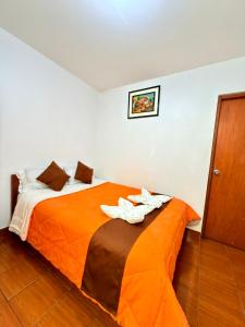 a bedroom with a bed with two lilies on it at Sunrise Guest House in Huaraz