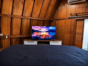 a bedroom with a tv and a bed with a fire at Wavez Bungalow in Selong Belanak +5 photos