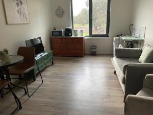 a living room with a couch and a table at Guinevere 2 in Myrtleford